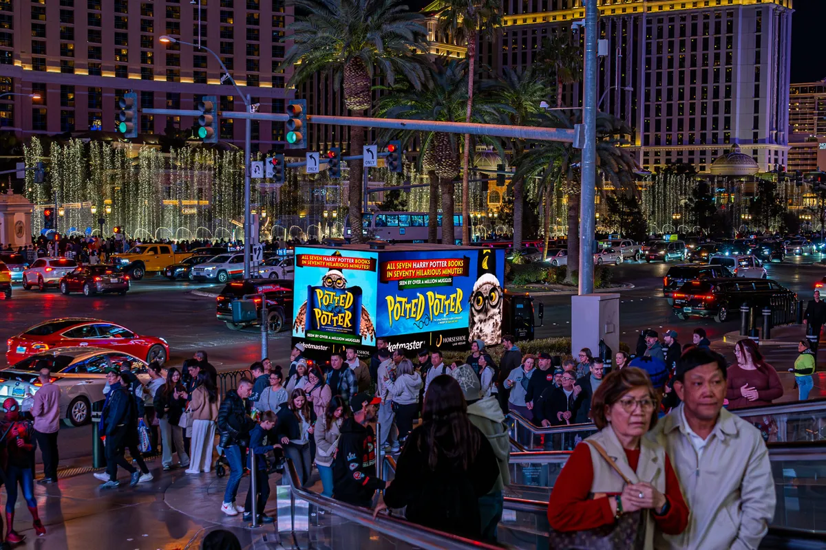 LED mobile billboard trucks driving through crowded Las Vegas city streets at night reaching thousands