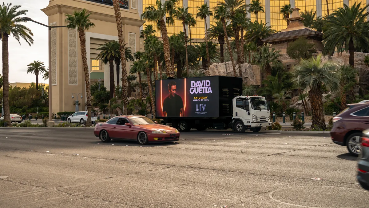 Single mobile billboard truck advertising on the Las Vegas Strip during daytime near major hotels